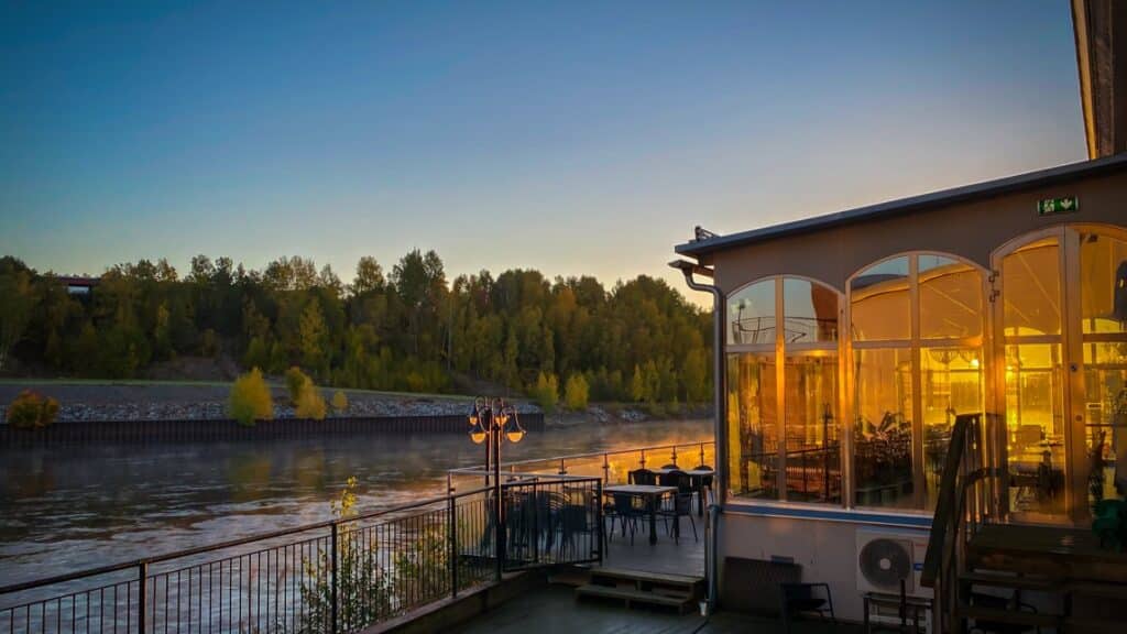 Solen går ner över vattnet från en restaurangs däck.