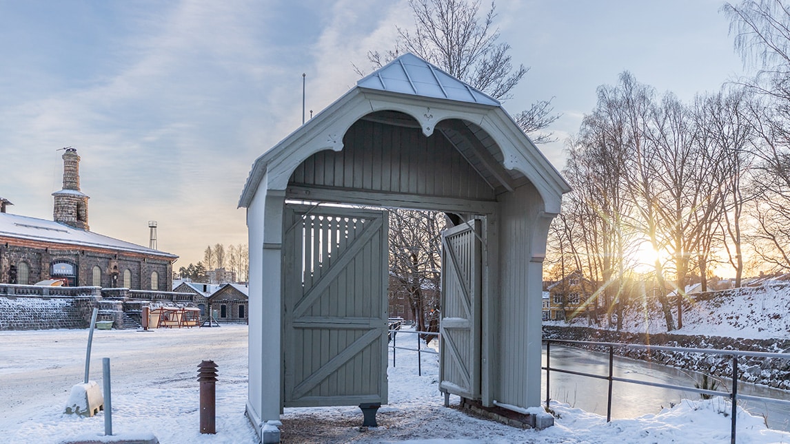 Äldre träportal med tunga portar.