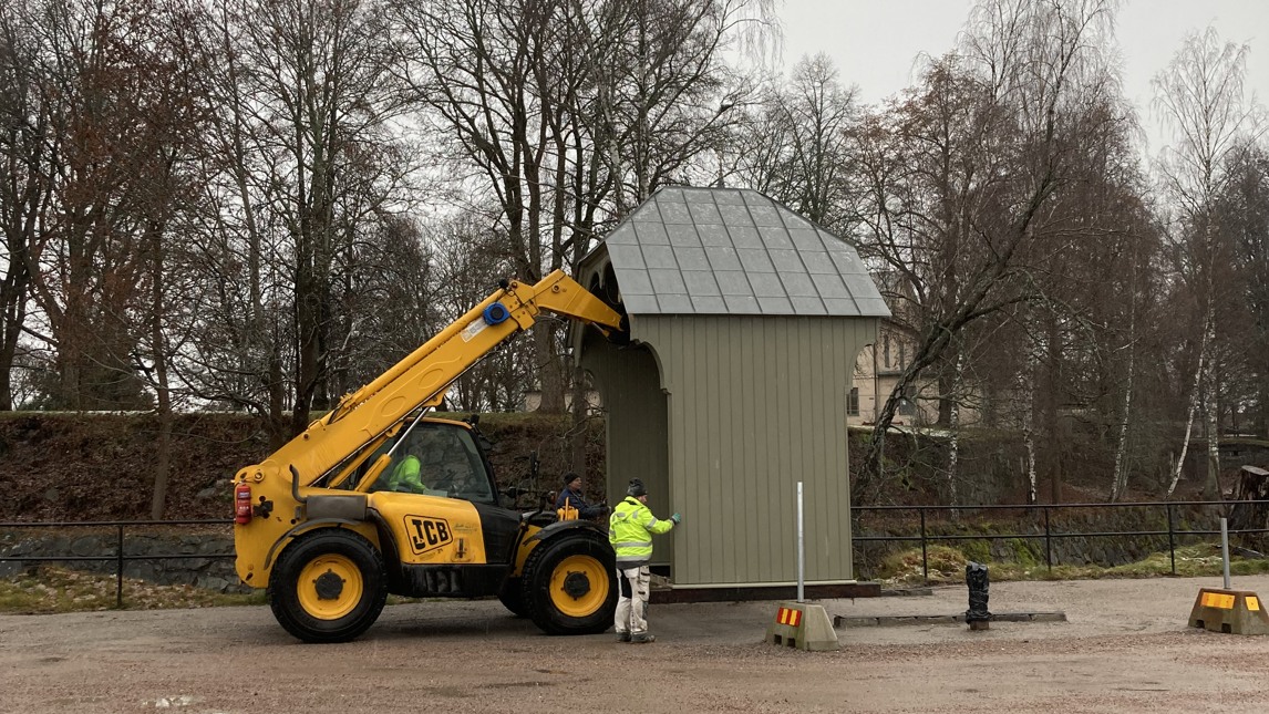 En lyftmaskin flyttar en stor port.