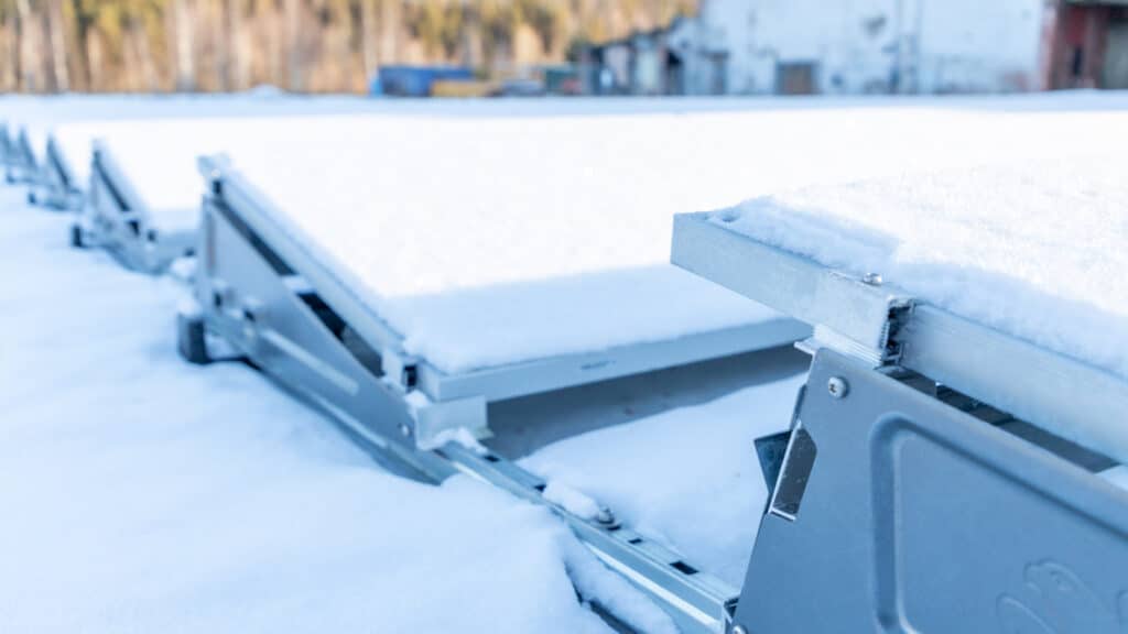 En rad solcellspaneler täckta av snö.